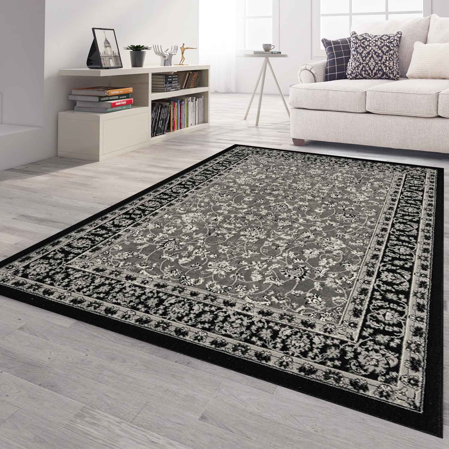 Oriental rug, grey and black, classically densely woven with ornament and floral motifs.